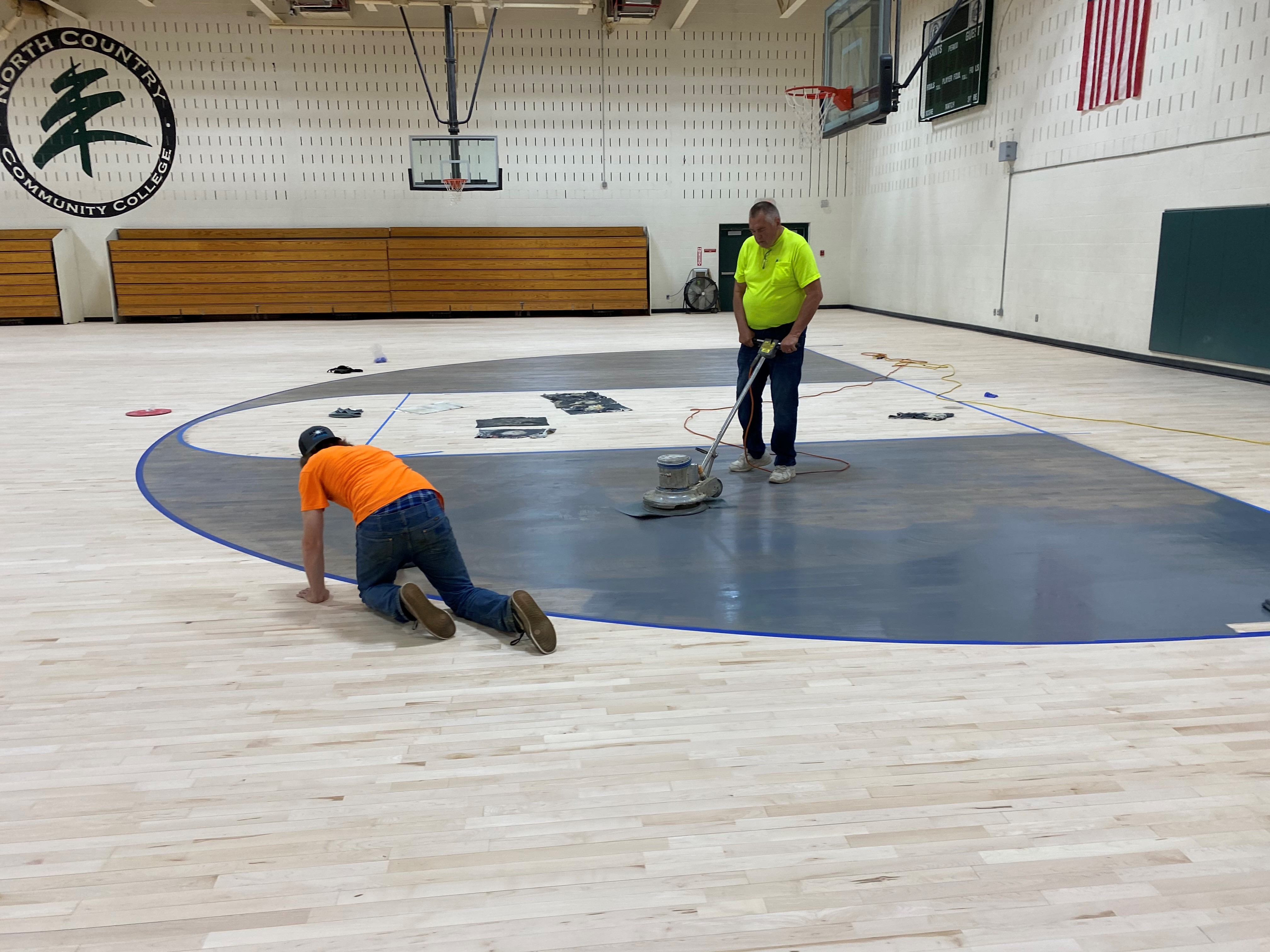 Painting and buffing the new gym floor.