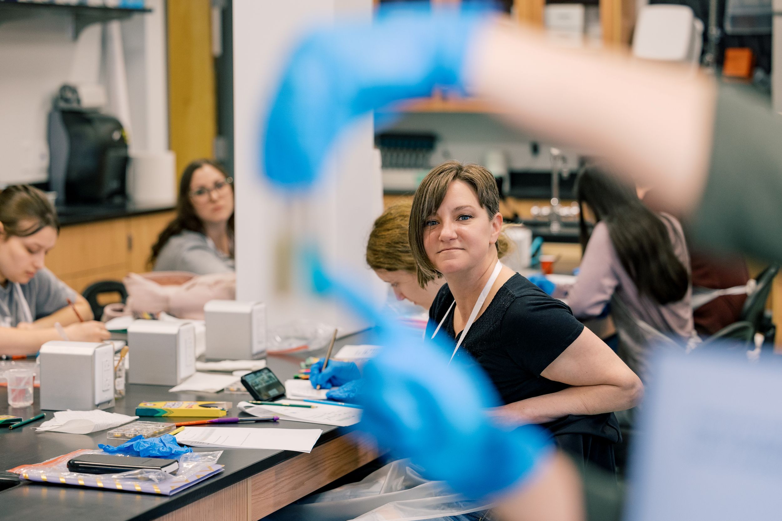 A student smiles as she listens to a lesson in a chemistry lab