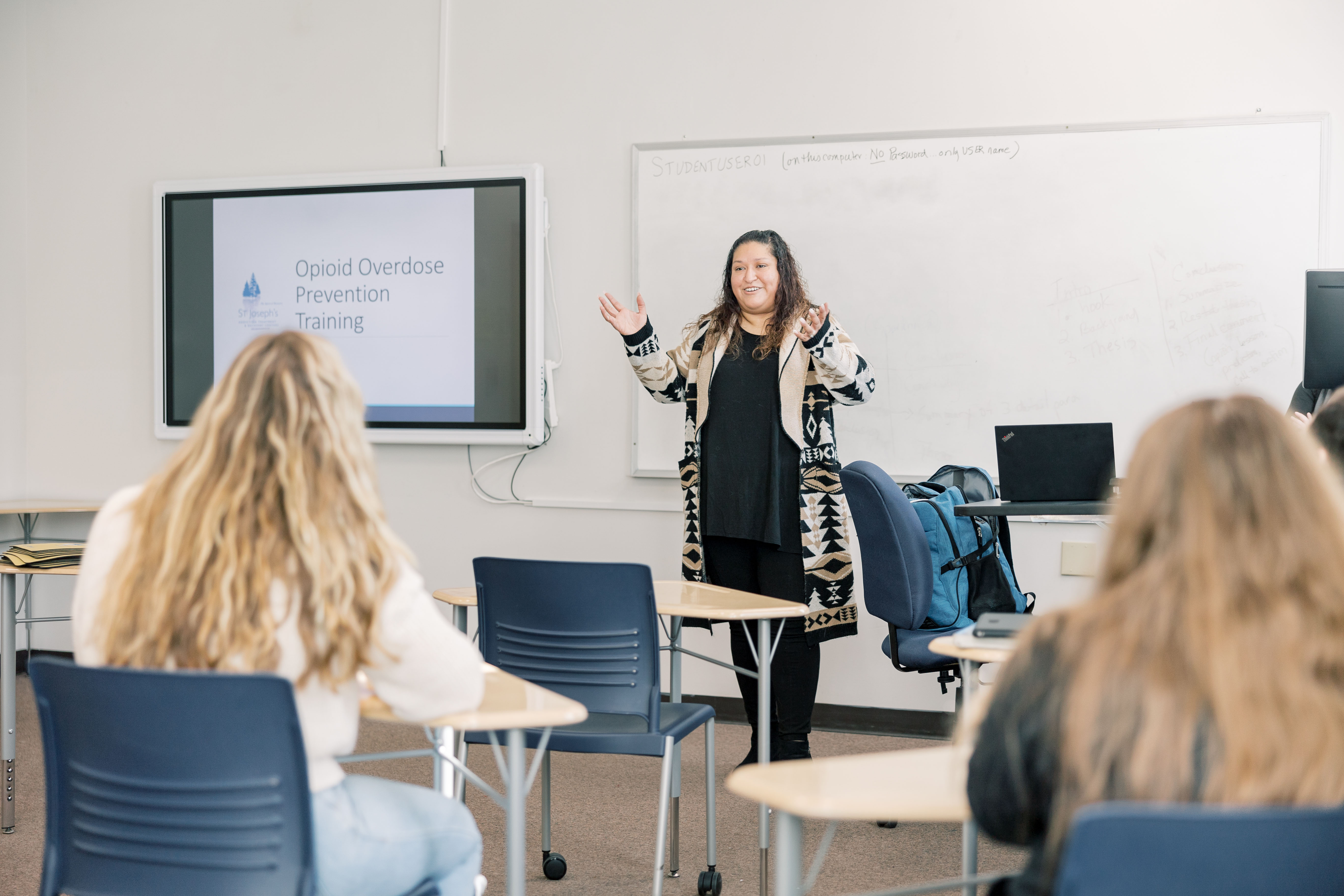 An instructor stands in front of a class of students