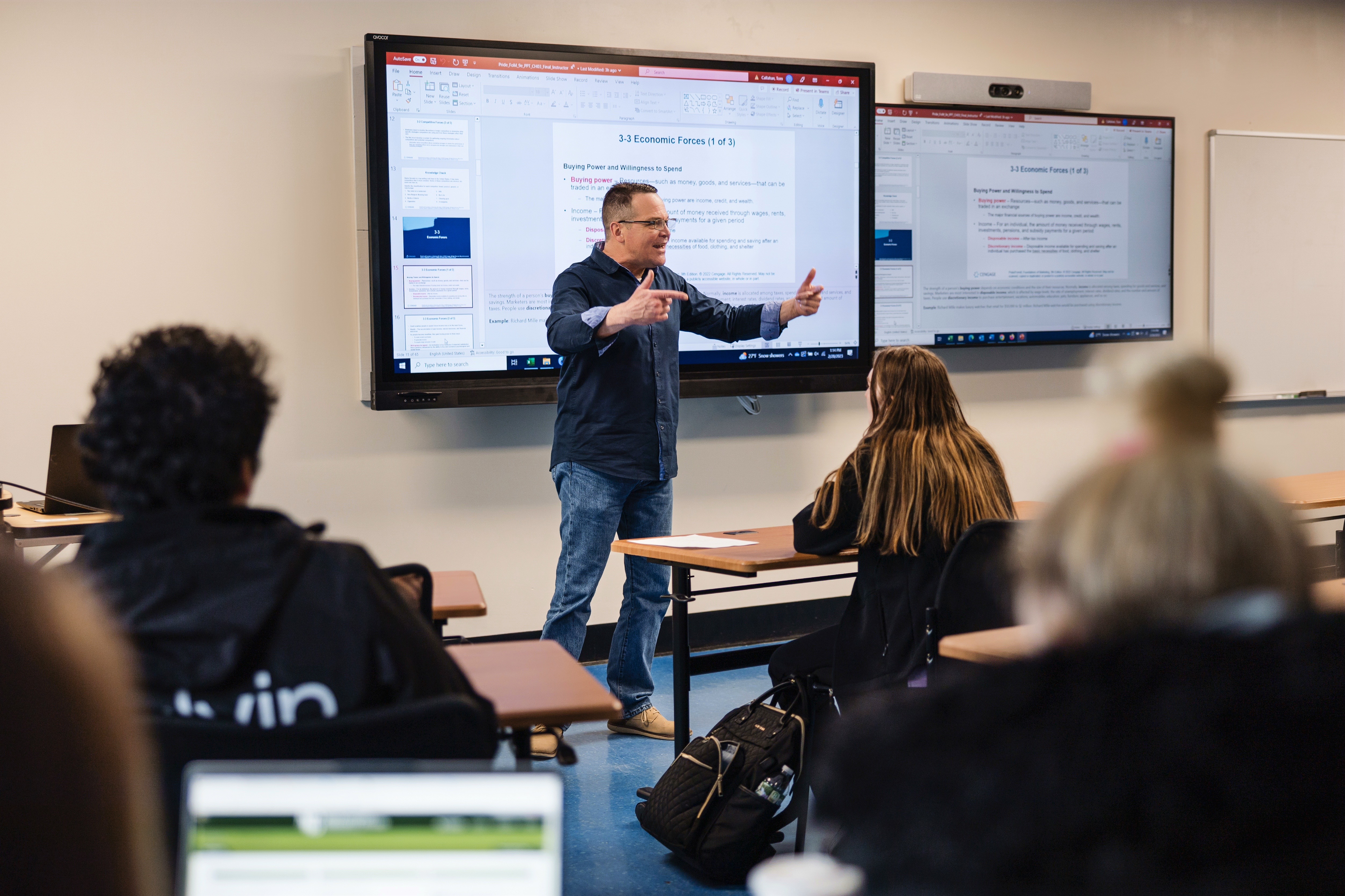 An instructor leads a class of students during a business class