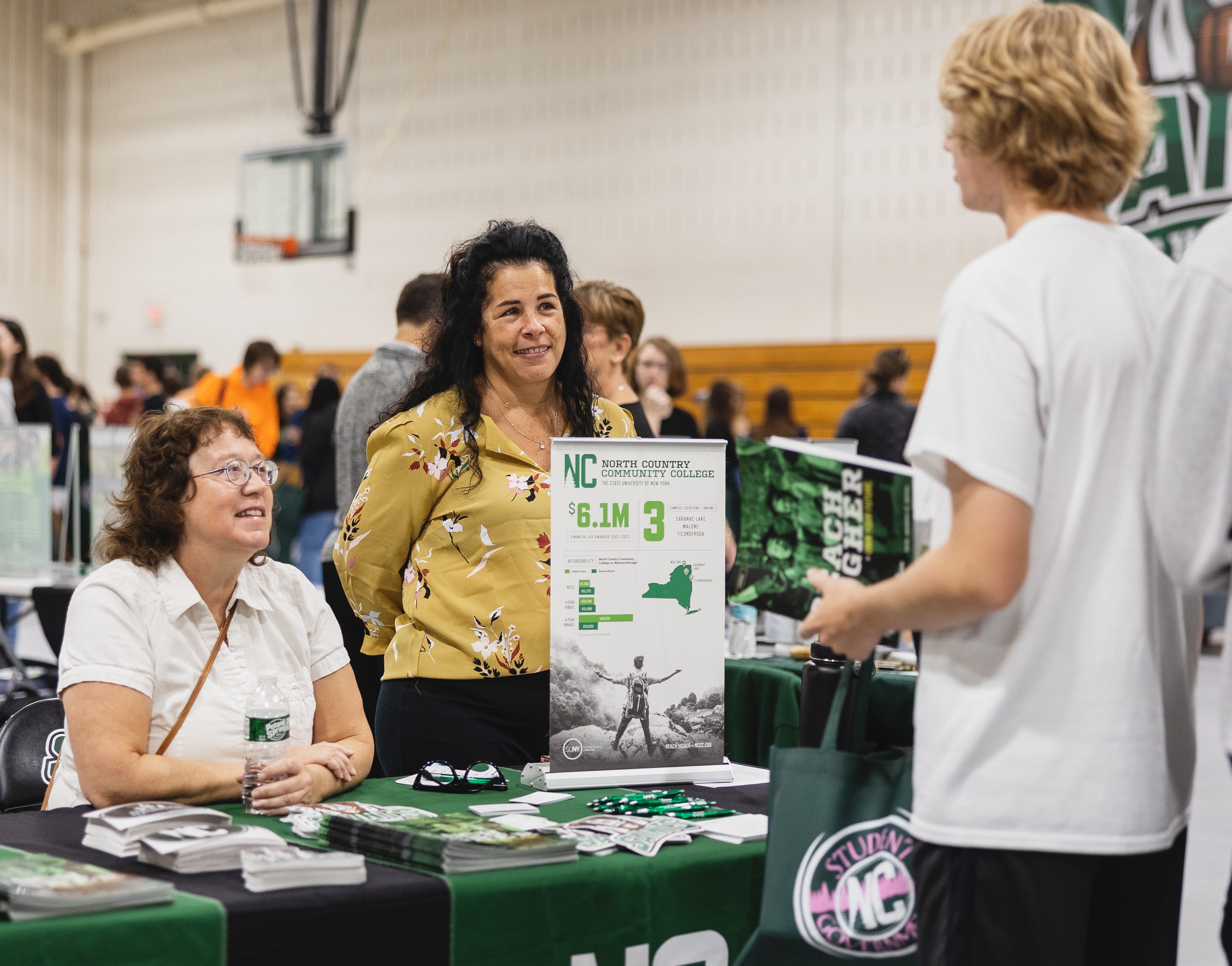 College employees talk with a prospective student.