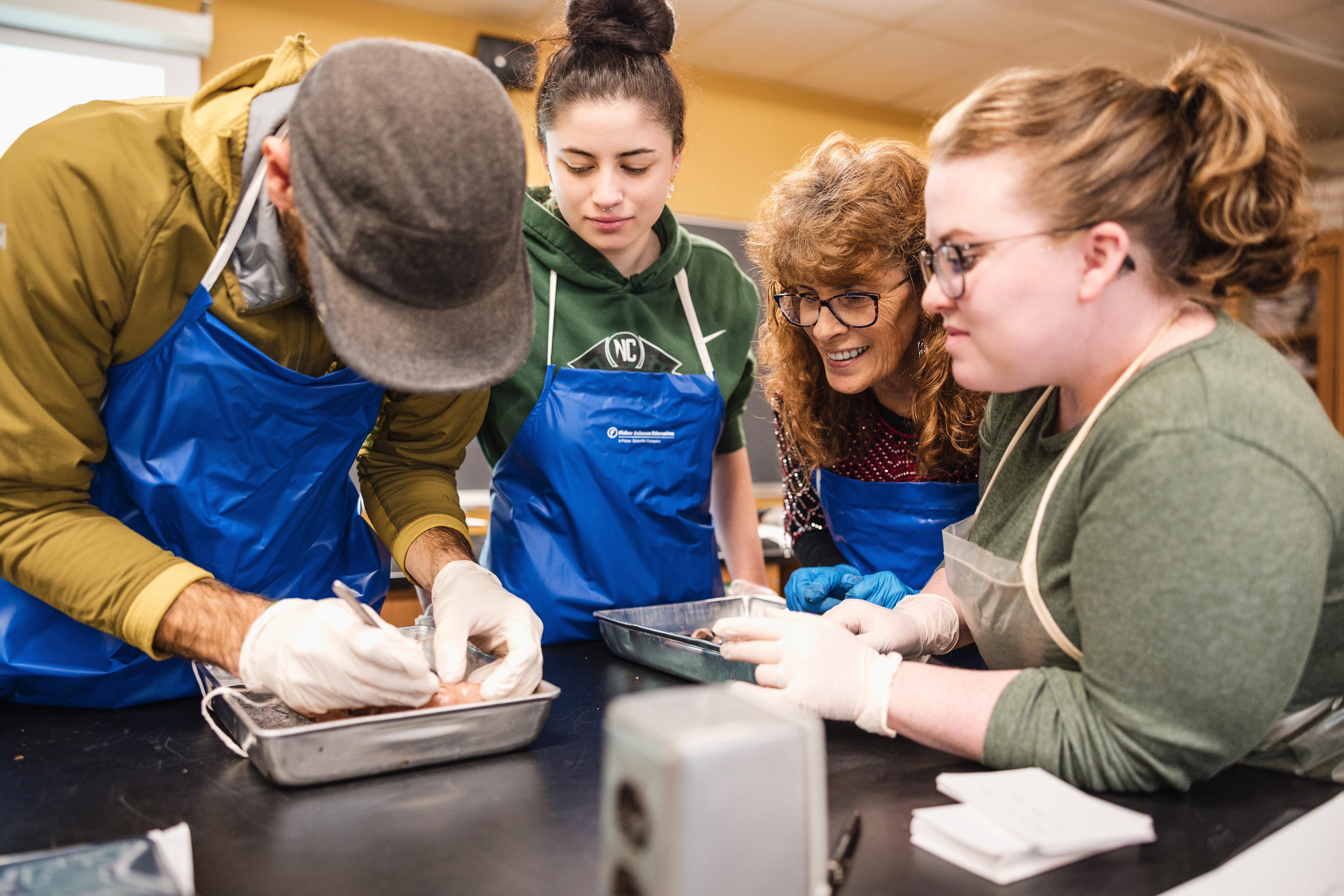 An instructor works with students in a science lab.