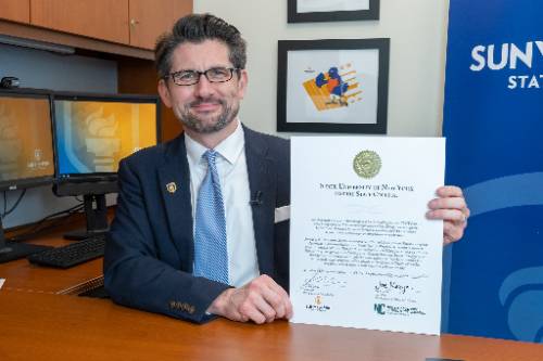 President Jim Malatras holds up the new transfer pathway agreement between SUNY Empire and NCCC