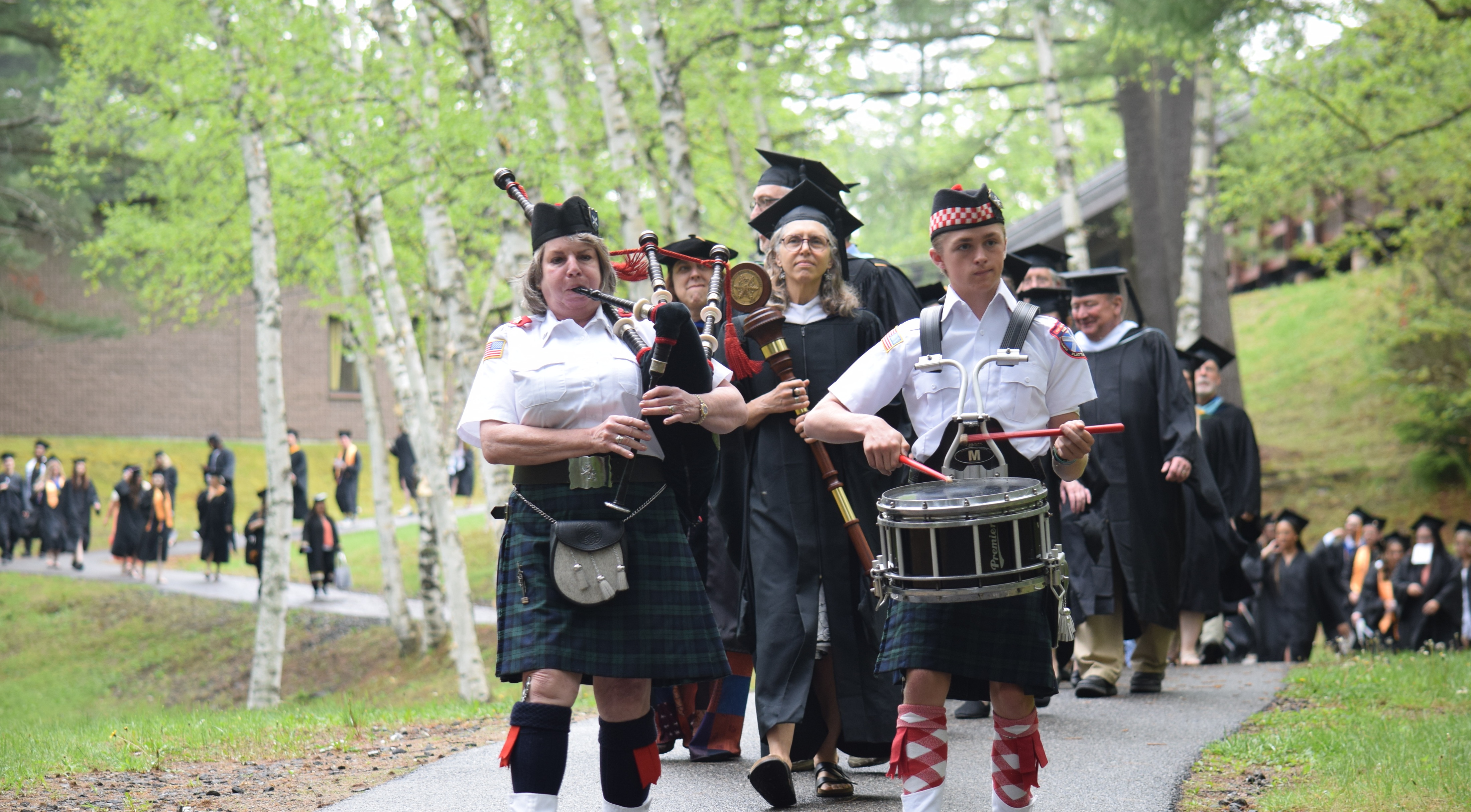 Led by bagpipers, the college's faculty and the Class of 2025 march to the Sparks Athletic Complex for Commencement