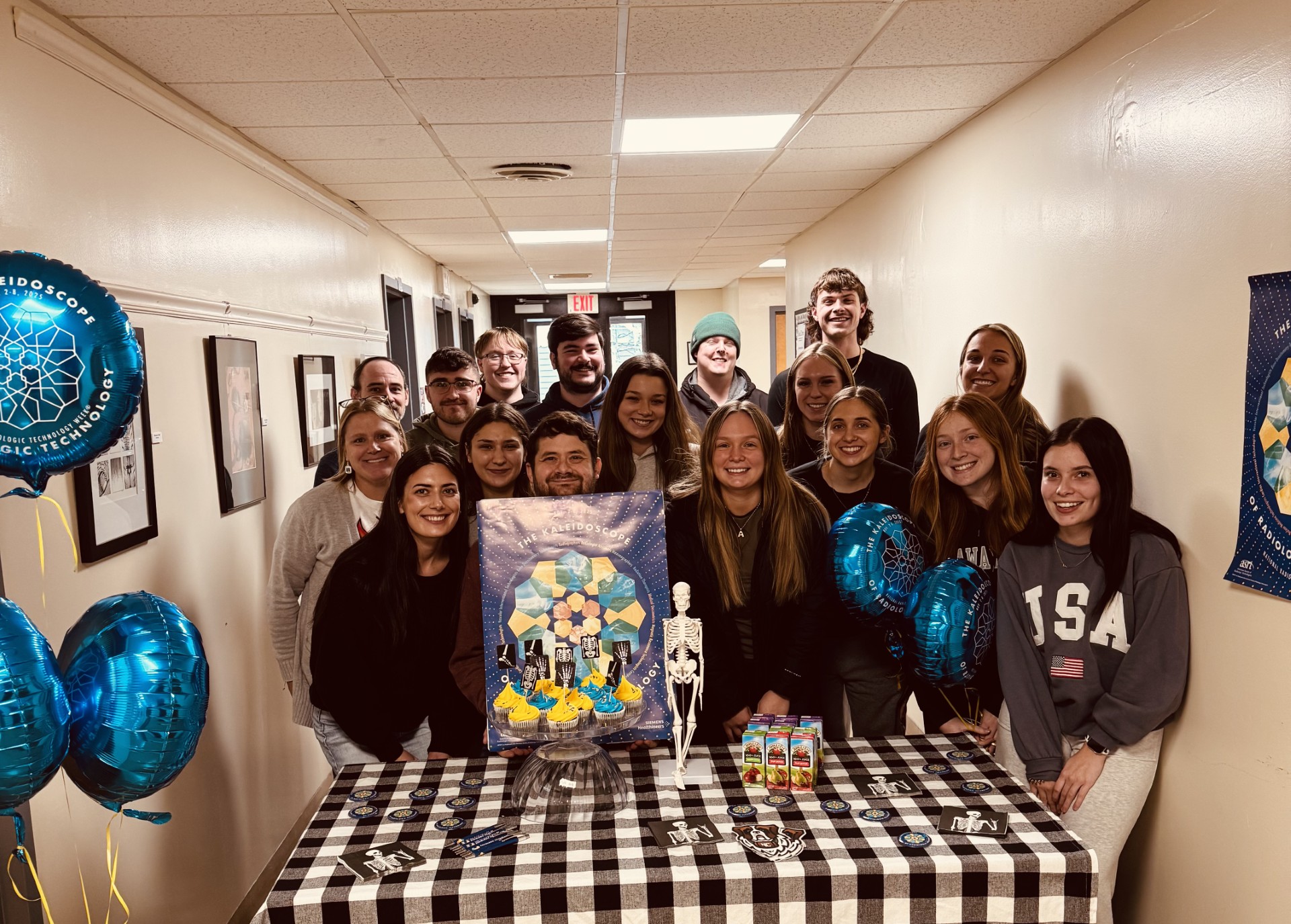 Students stand in a hallway and smile for the camera 