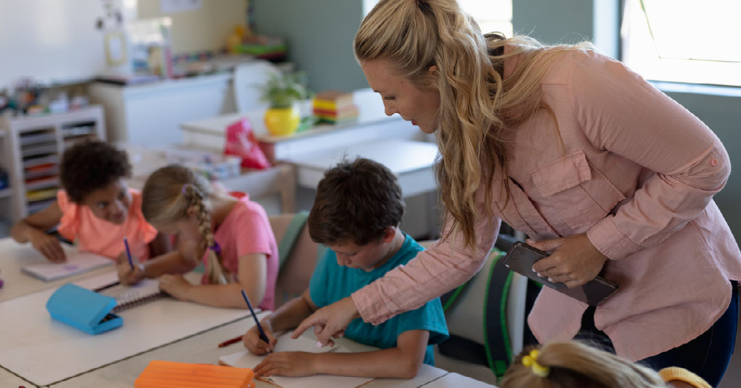 A teacher works with children in a classroom