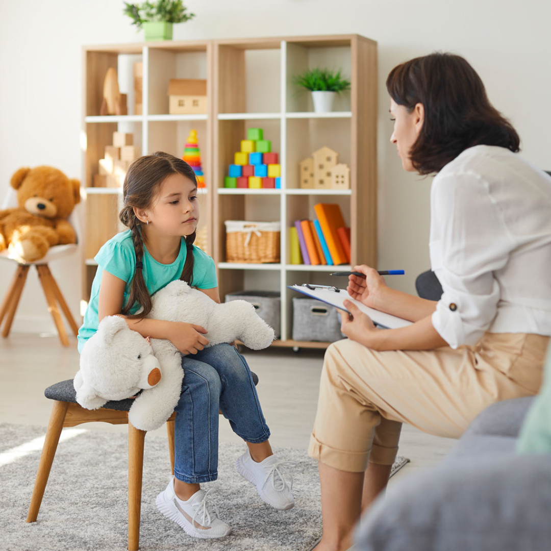 An adult talks with a young student