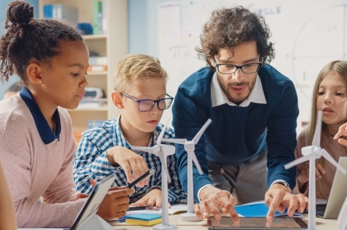 A teacher works with students in a classroom